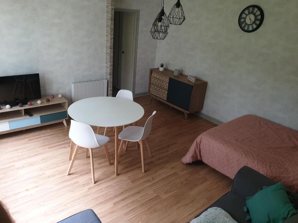 - un salon avec une table, des chaises et un lit dans l'établissement Appartement, Verdun , proche centre ville, à Verdun-sur-Meuse