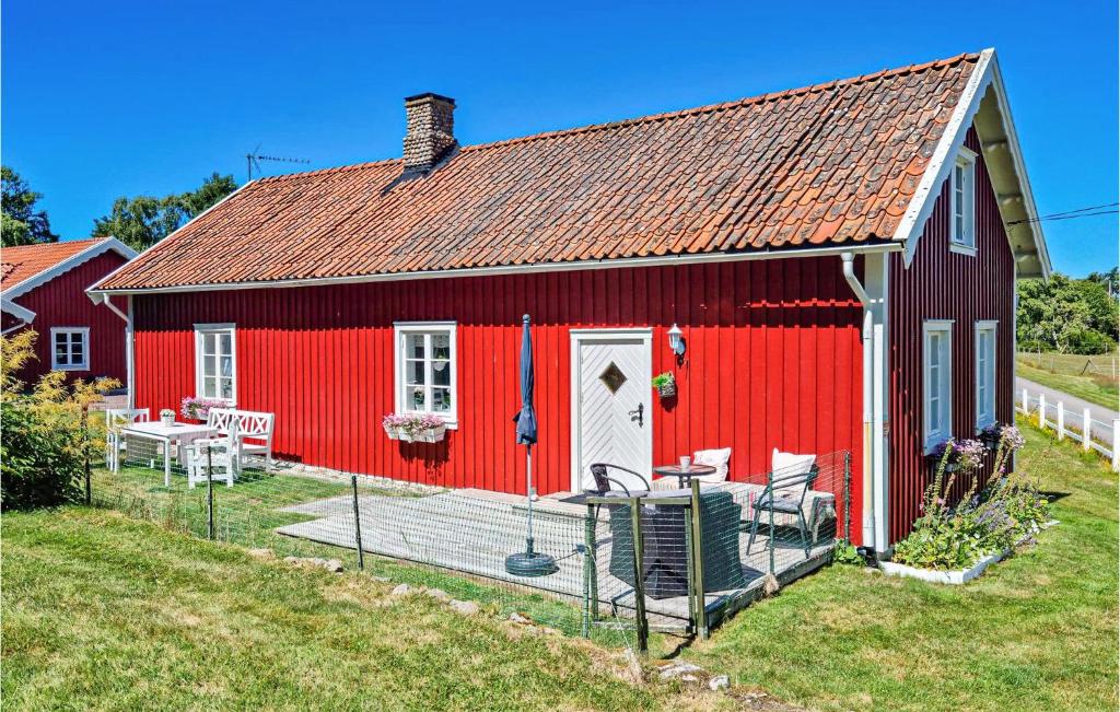 a red barn with a table and chairs in front of it at Nice Home In sa With Kitchen in Åsa