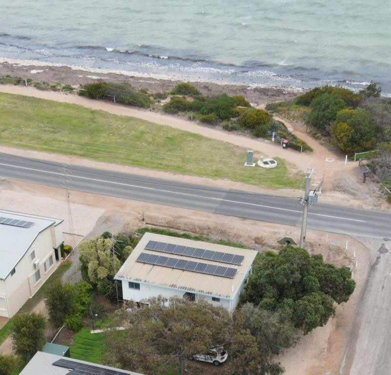 an aerial view of a building with solar panels on the beach at Seafront Shack in Port Hughes