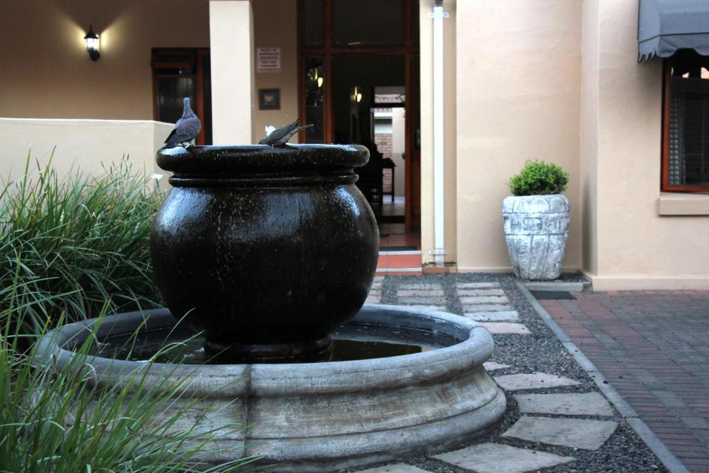 um grande vaso preto sentado em frente a um edifício em Del Roza Guest House em Middelburg