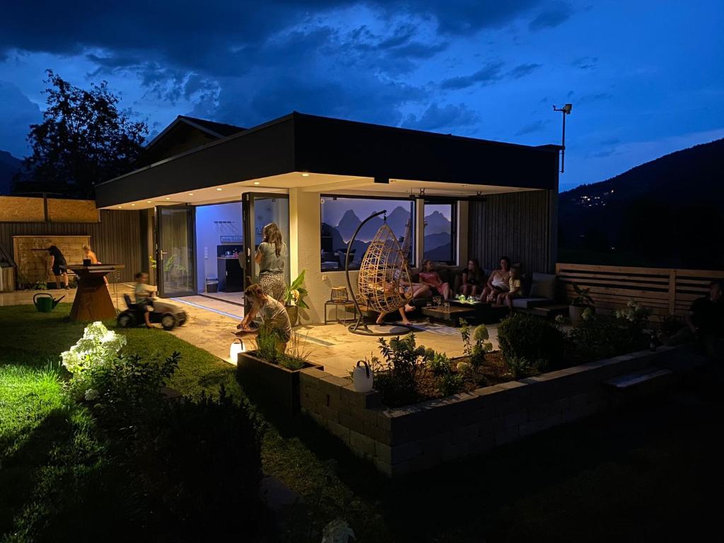 a group of people sitting on a patio at night at Appartements-Pension Lindenheim in Schladming