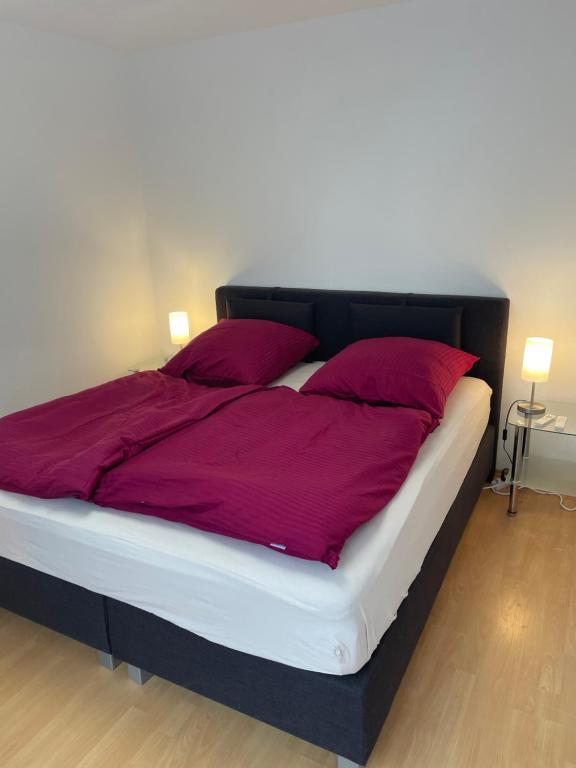 ein großes Bett mit lila Bettwäsche und Kissen in der Unterkunft Zimmer im Herzen von Durlach in Karlsruhe