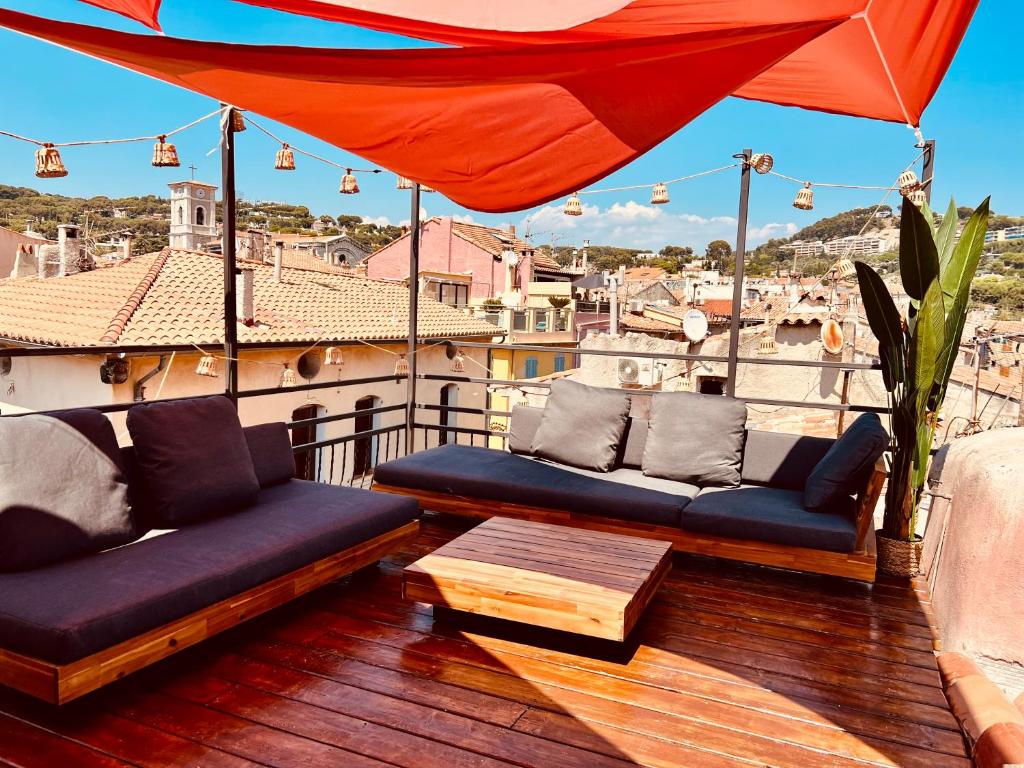 un balcone con due divani, un tavolo e un ombrellone di CALANQUE D'EN VAU a Cassis