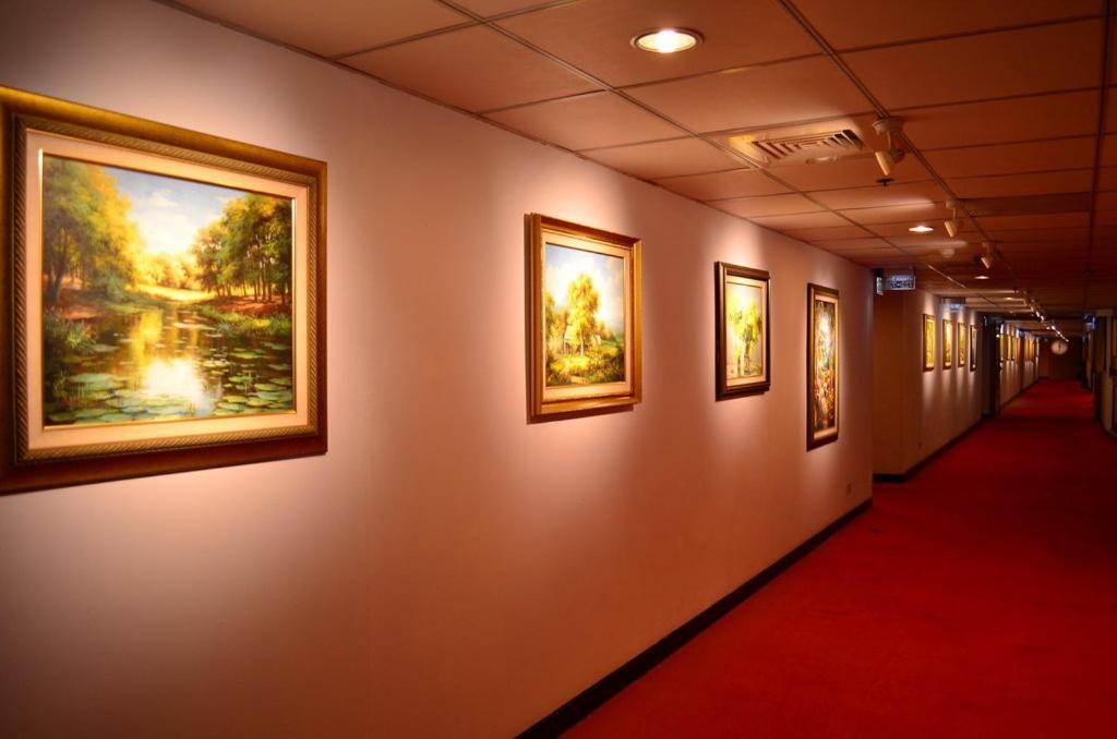a hallway with paintings on the wall at The Premier Hotel in Tainan