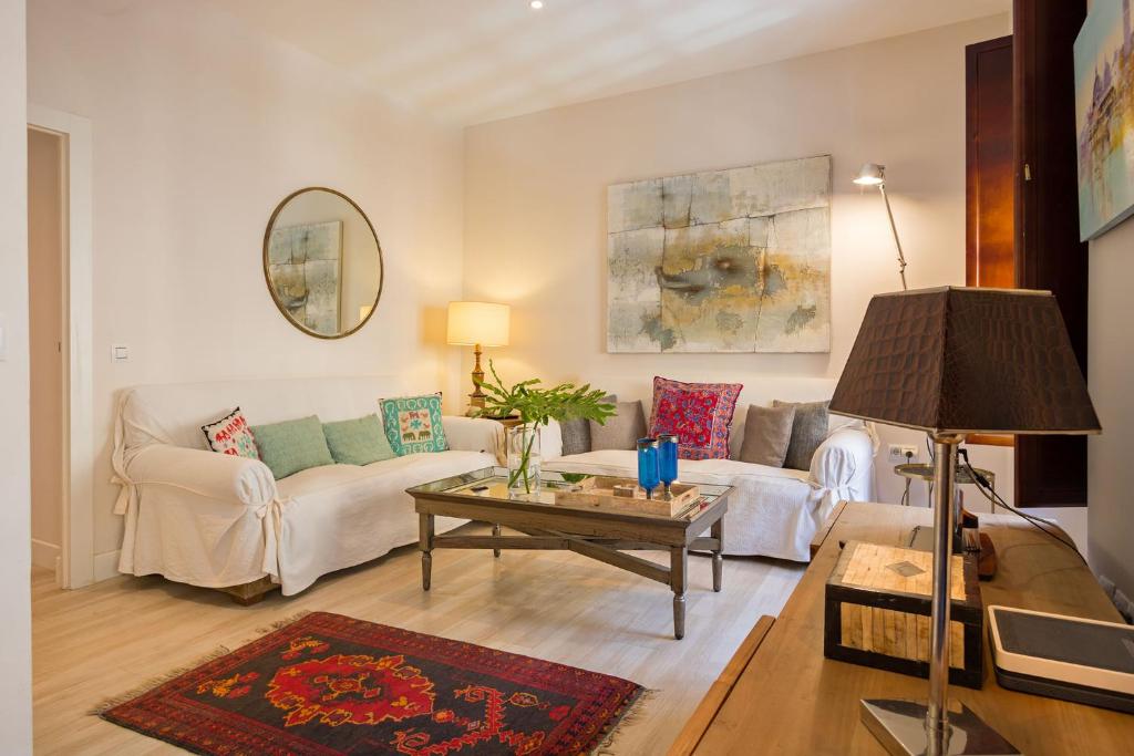 ein Wohnzimmer mit einem Sofa und einem Tisch in der Unterkunft Arenal Apartamento Centro Histórico 4 pax in Sevilla