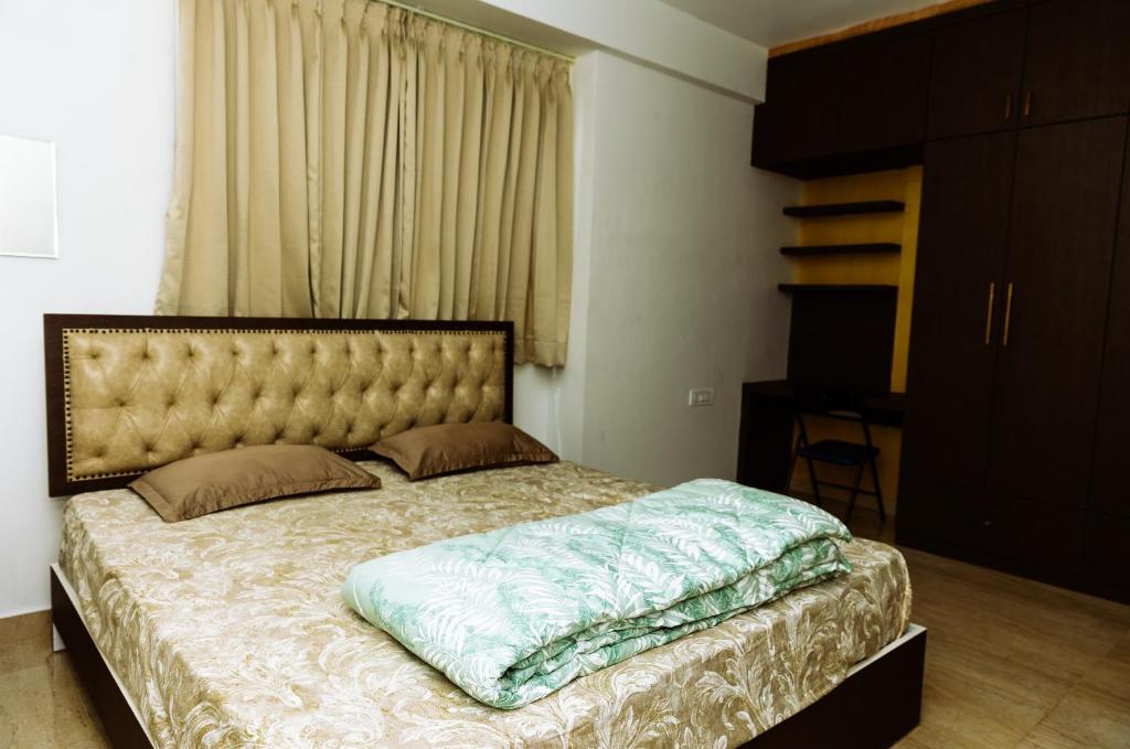 a bedroom with a large bed with a large headboard at RVR Home - Beautiful Rooms in Bangalore