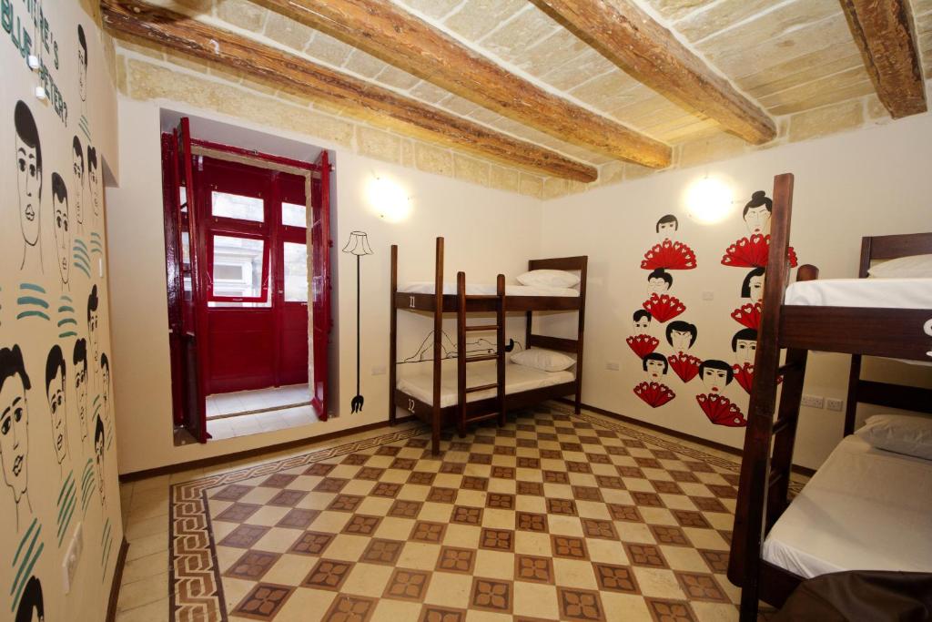 Habitación con puerta roja y dormitorio en Vallettastay Dormitory shared hostel, en La Valeta