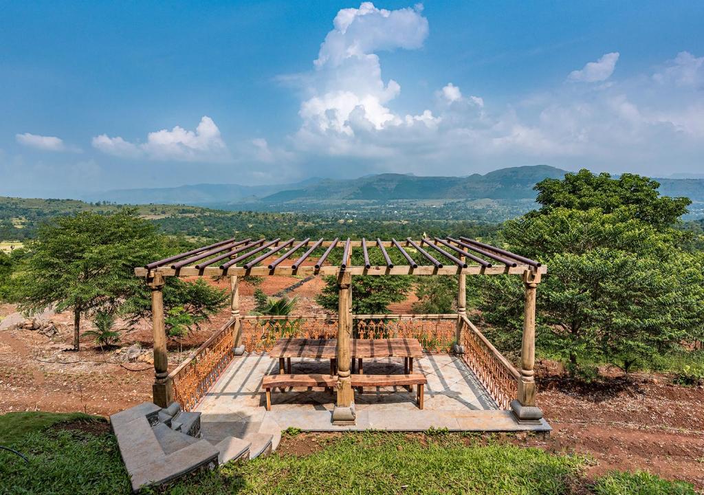 Mārg ĀsniにあるSaffronStays Niramay, Torna-Rajgad - rustic pool villa with a gazebo and great forest viewsのピクニック用のシェルター(テーブル、ベンチ付)