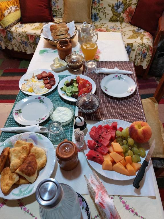 a table topped with plates of food and fruit at Guest House Mikel in Berat