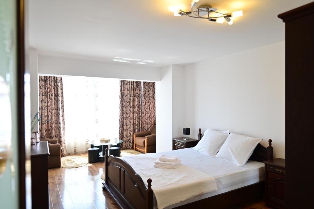 Schlafzimmer mit einem Bett und einem Fenster in der Unterkunft Vacation Apartment with free parking in Sibiu