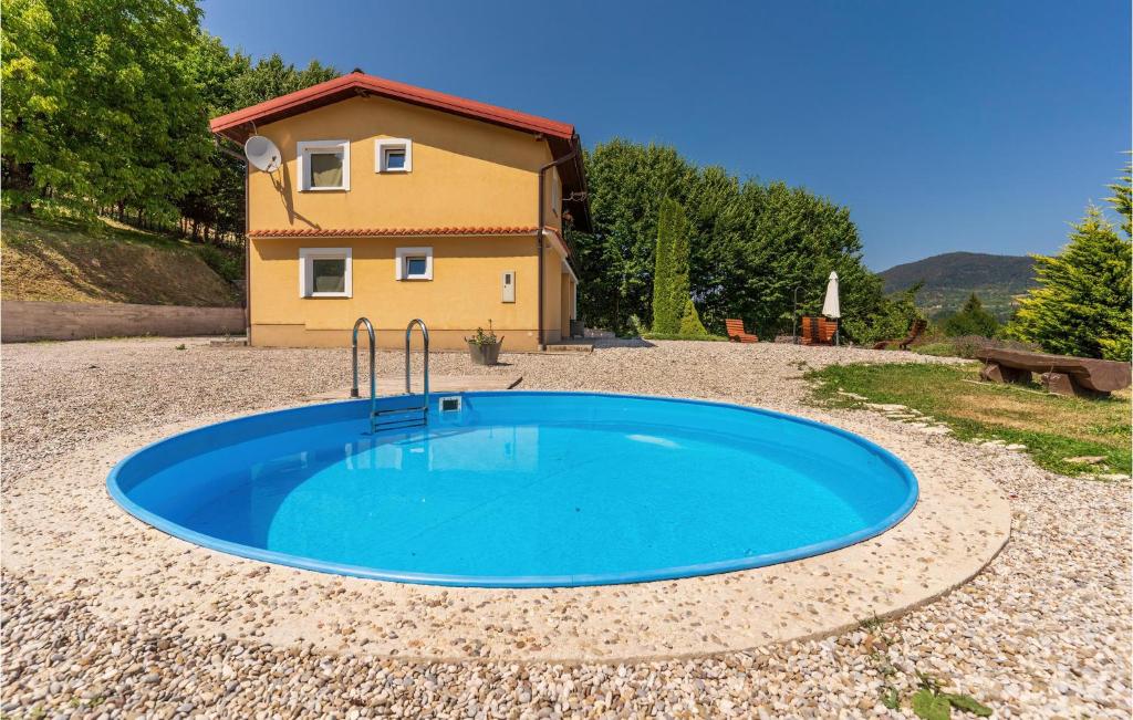 a small blue pool in front of a house at Nice Home In Vrbovsko With 5 Bedrooms, Wifi And Outdoor Swimming Pool in Vrbovsko