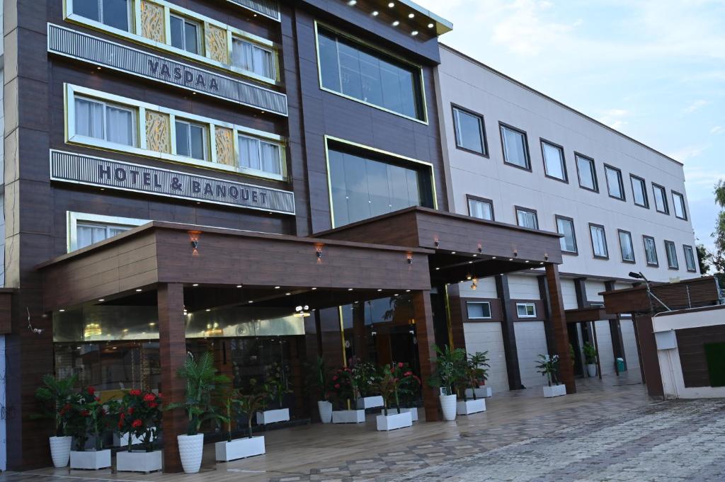 a hotel with plants in front of a building at Hotel Vasdaa Grand in Dehradun