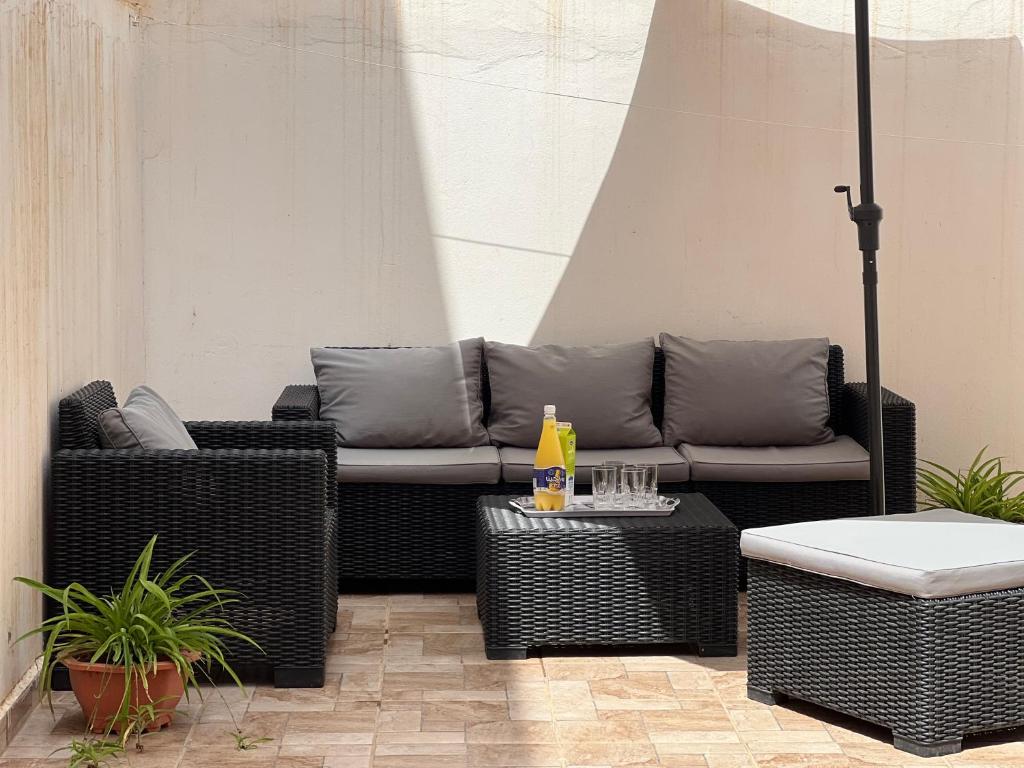 eine Terrasse mit Korbstühlen und einem Sofa in der Unterkunft maison du bonheur en bord de mer avec piscine in Saidia 