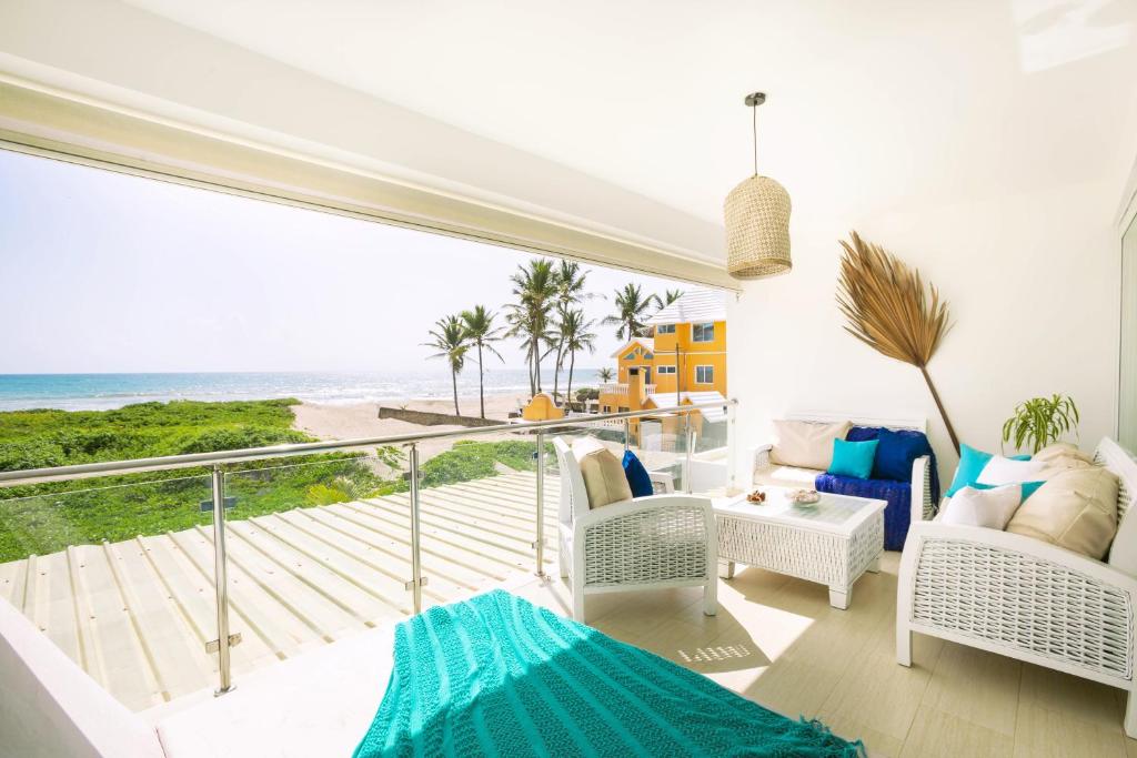 een woonkamer met een balkon met uitzicht op de oceaan bij Amazing Ocean Front - 2 bedroom Apartment (117 sq meters) in Cabarete