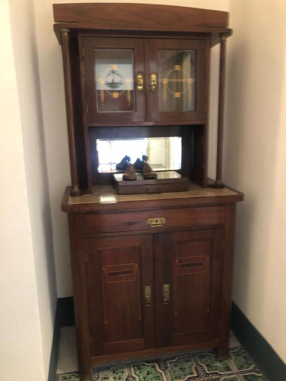 a large wooden cabinet in the corner of a room at Palazzo Bernardini Suites in Lecce