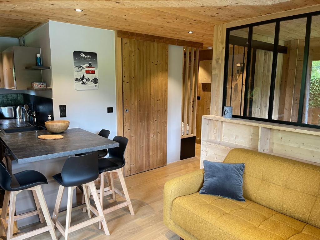 cocina y sala de estar con mesa y sofá en Marmotte du Jaillet Cosy and charmant appartement en Demi-Quartier