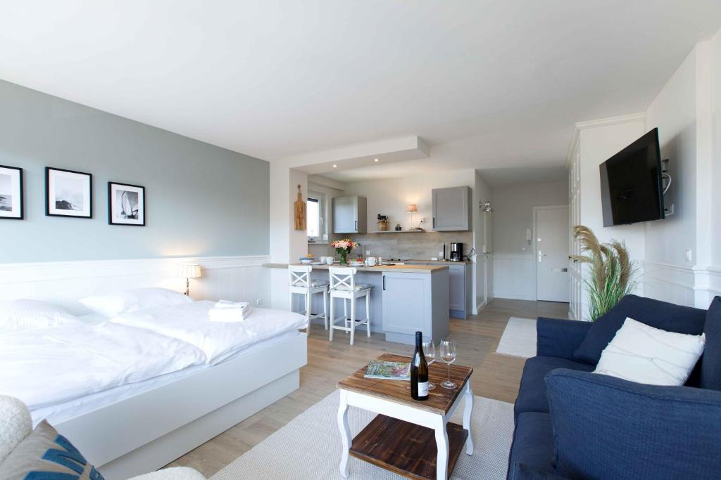 - un salon avec un lit blanc et un canapé bleu dans l'établissement Strandbude, à Büsum