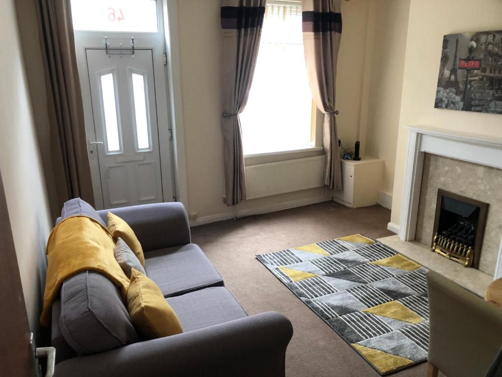 a living room with a couch and a fireplace at 4-Bedroom House Close to Barnsley Centre in Barnsley