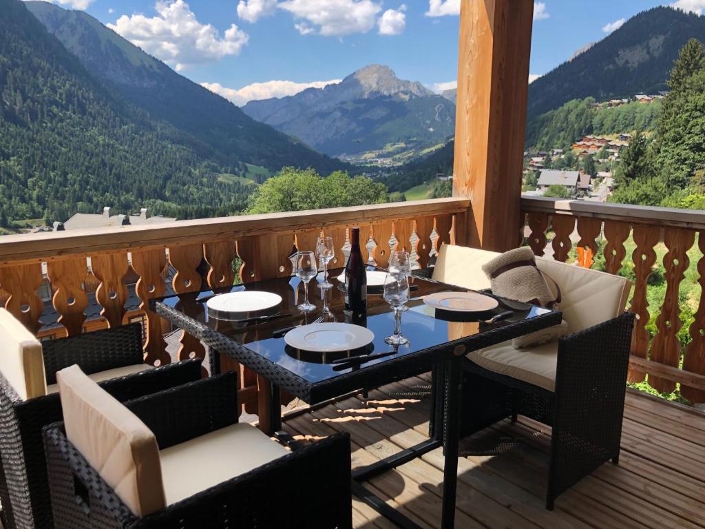 d'une table sur un balcon avec vue sur les montagnes. dans l'établissement Apartment A304 La Perle de Savoie, à Châtel