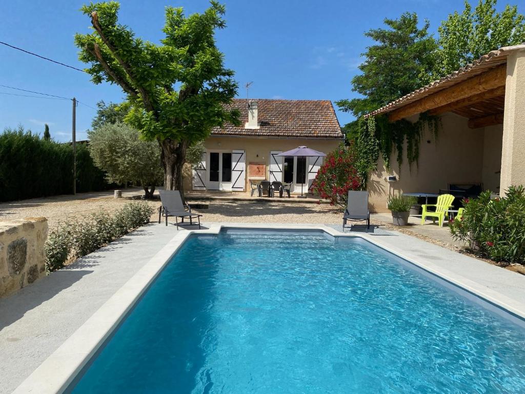 una piscina con 2 sillas y una casa en Les Célestins - Villa en Provence, en Carpentras