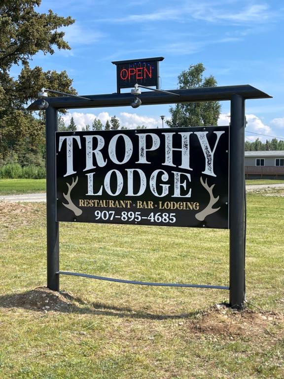 a sign for a property lodge in a field at Trophy Lodge Accommodations in Delta Junction