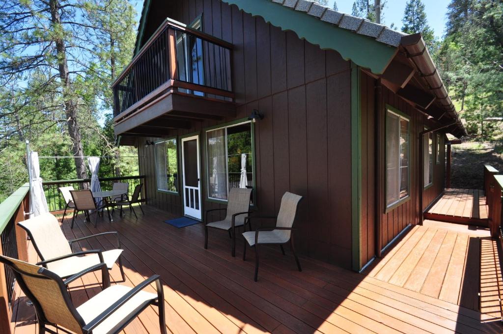 Cette maison dispose d'une terrasse avec des chaises et d'un balcon. dans l'établissement Bigfoot Cabin at Pine Mountain Lake, à Groveland