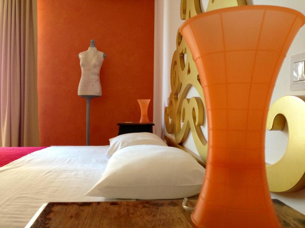 een slaapkamer met een bed met een oranje muur bij B&B Ebo' in Olbia