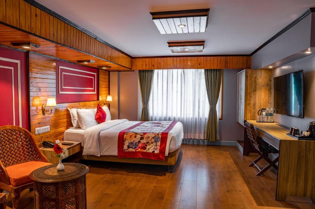 um quarto de hotel com uma cama e uma secretária em Mount Conifer Suites & Spa em Darjeeling