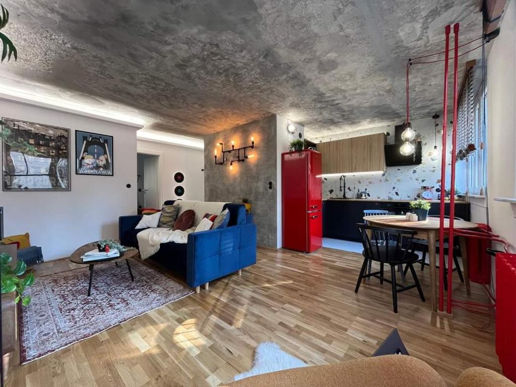 a living room with a blue couch and a red refrigerator at Modern Retro Apart ~ 800m Main Square in Wrocław