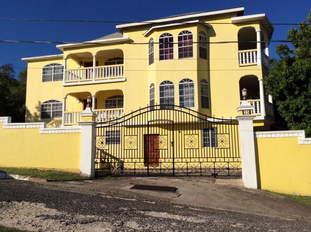 une maison jaune avec une porte devant elle dans l'établissement Pura Vida Jamaica, à Falmouth