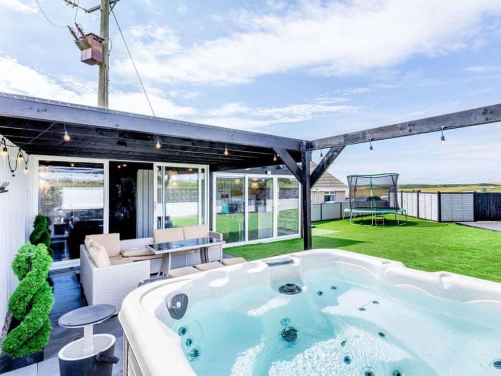 a jacuzzi tub in the backyard of a house at Tigh Na Mhor , Hot Tub , Games Room , 5 Bedroom ,Sleeps 13 , Large Villa in Cruden Bay
