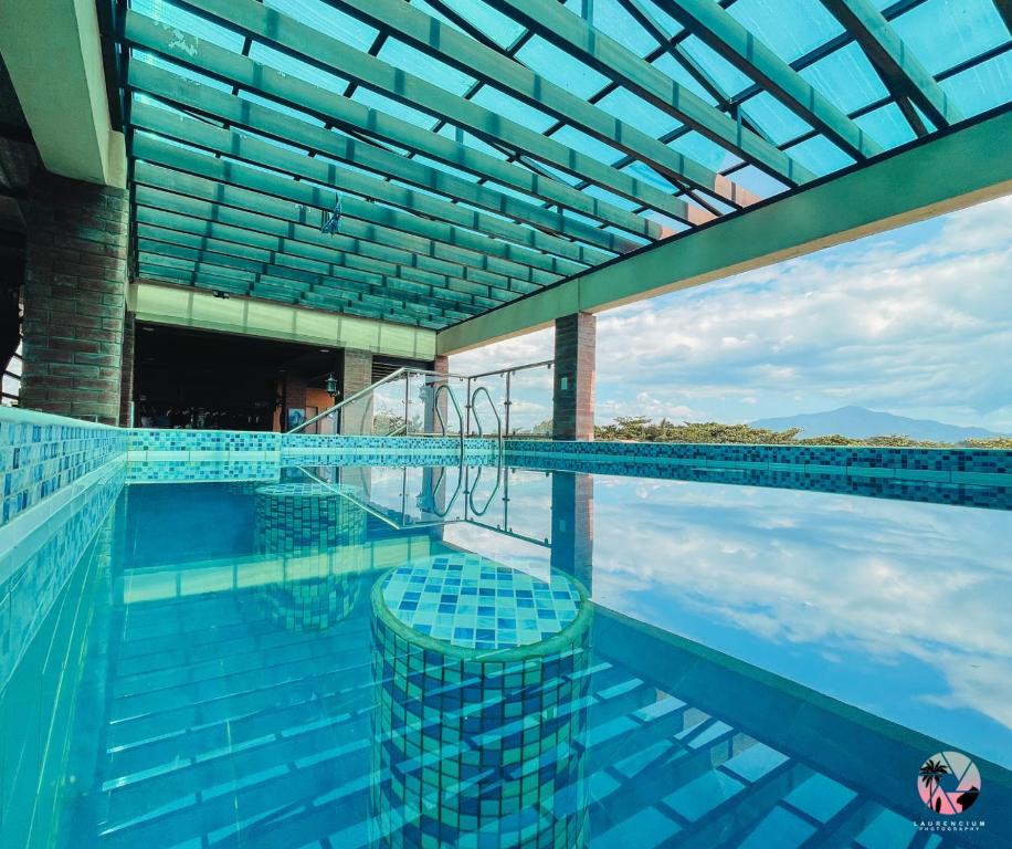 una piscina con azulejos azules y techo de cristal en The Palms Resort & Bar, en San Narciso