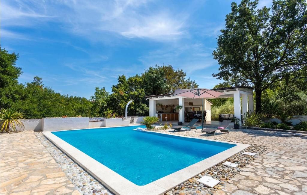 a swimming pool in a backyard with a gazebo at Amazing Home In Malinska With 2 Bedrooms, Wifi And Outdoor Swimming Pool in Malinska