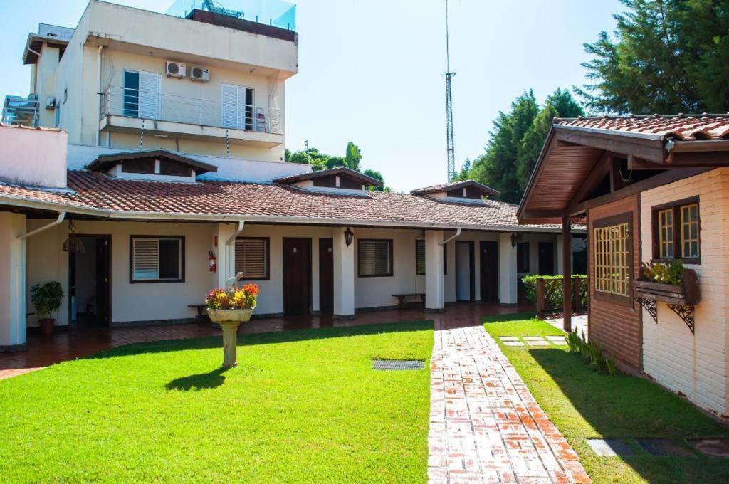 einen Innenhof eines Hauses mit einem grünen Hof in der Unterkunft Galeria Hotel Pousada in Jaguariúna