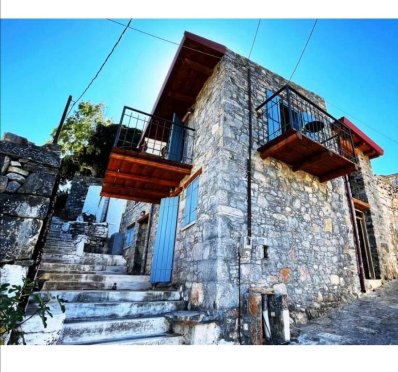 - un bâtiment en pierre avec des escaliers et des balcons dans l'établissement Pappou's Traditional Cottage at Epano Elounda, à Elounda