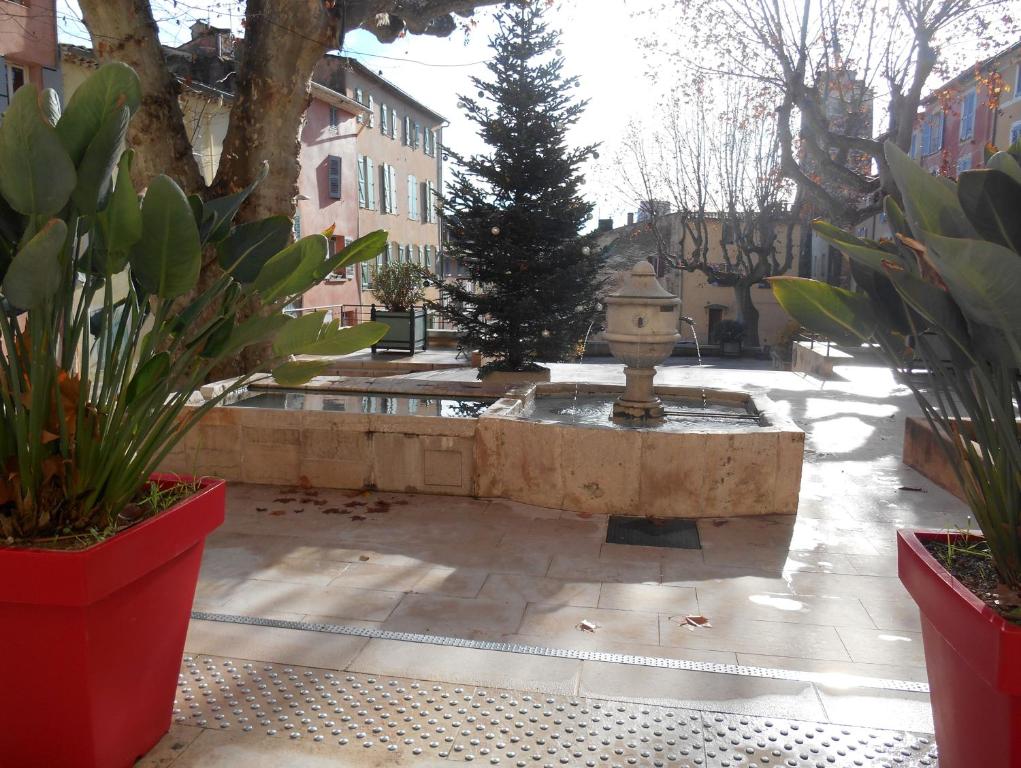a courtyard with a fountain and trees and plants at Entre Saint-Tropez et les gorges du Verdon. in Lorgues