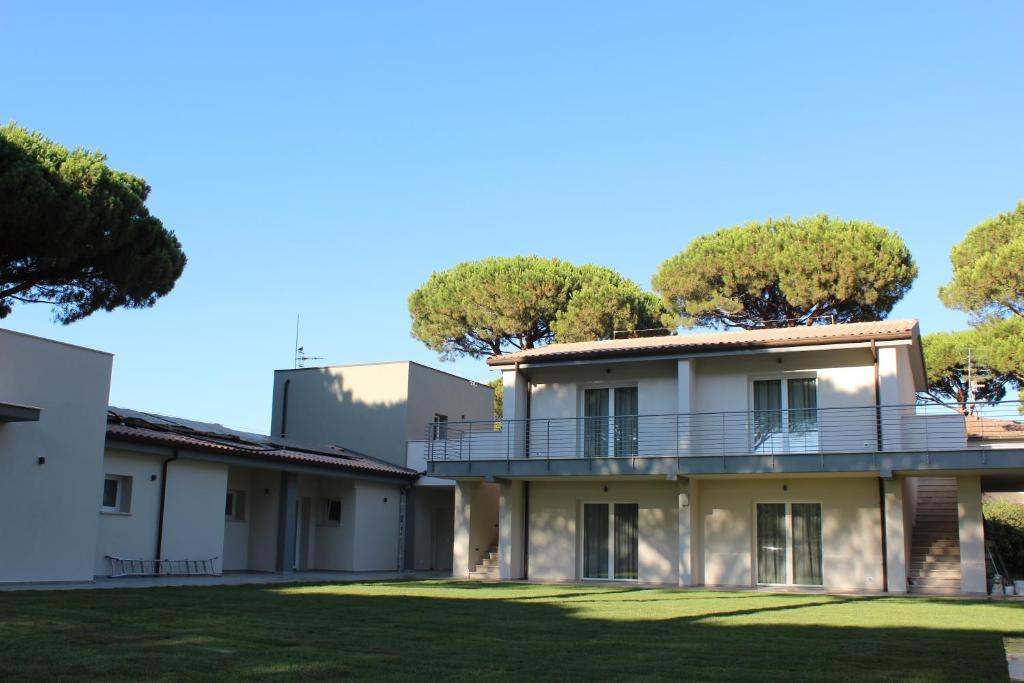 ein Bild eines Hauses mit Bäumen im Hintergrund in der Unterkunft Tennis Rocchette Resort in Castiglione della Pescaia