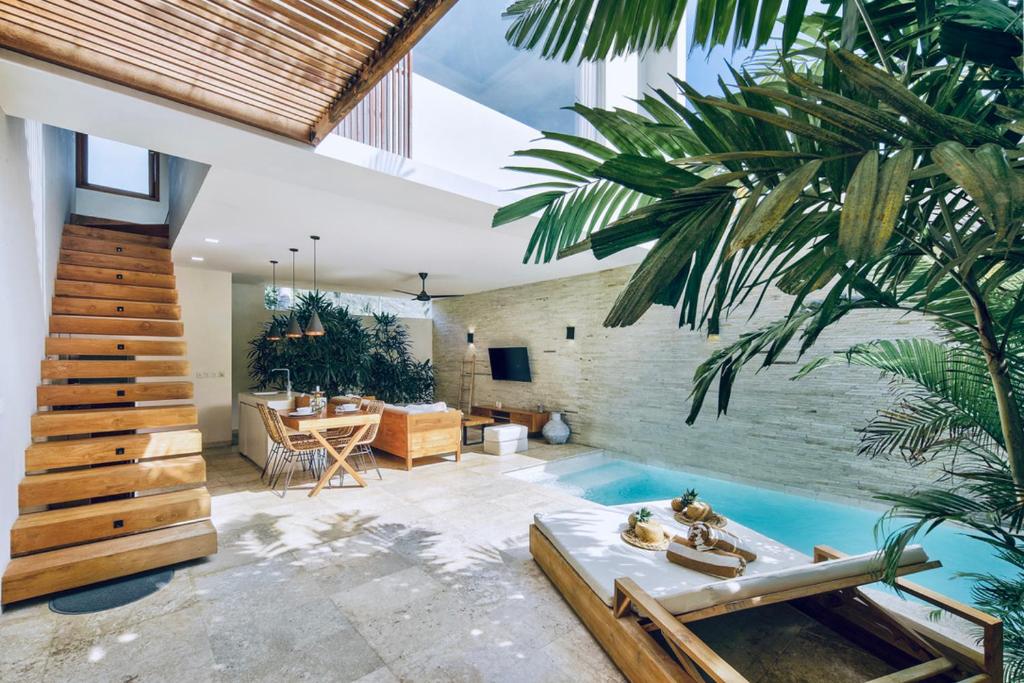 una sala de estar con piscina y una casa en Kabila Villas, en Kuta Lombok