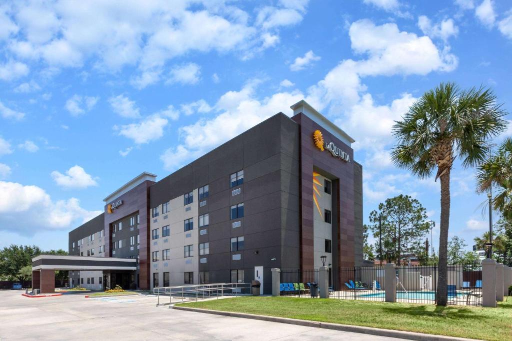 a hotel building with a palm tree in front of it at La Quinta by Wyndham Houston NW Brookhollow in Houston