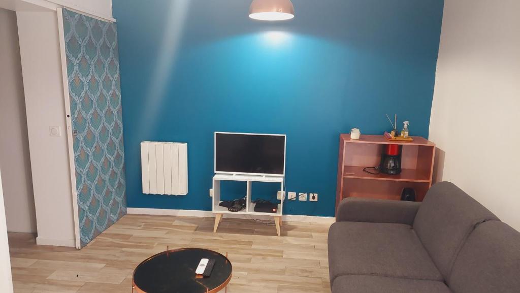 ein Wohnzimmer mit einem Sofa und einer blauen Wand in der Unterkunft Le Dessous des berges in Paris