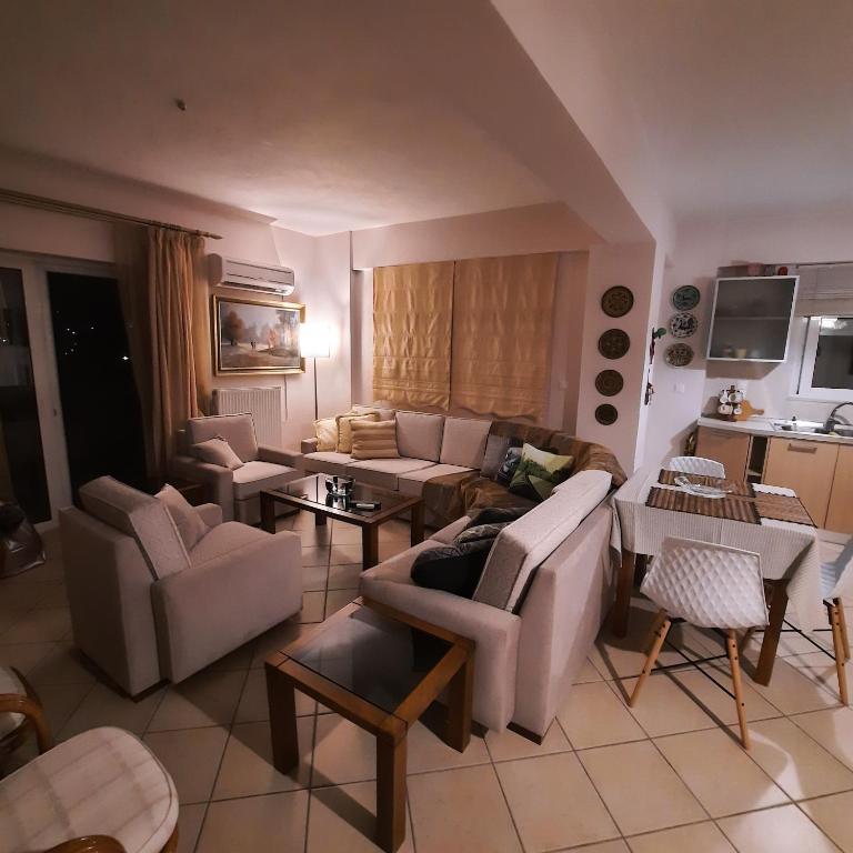 a living room with couches and chairs and a kitchen at piu verde1 in Nea Makri