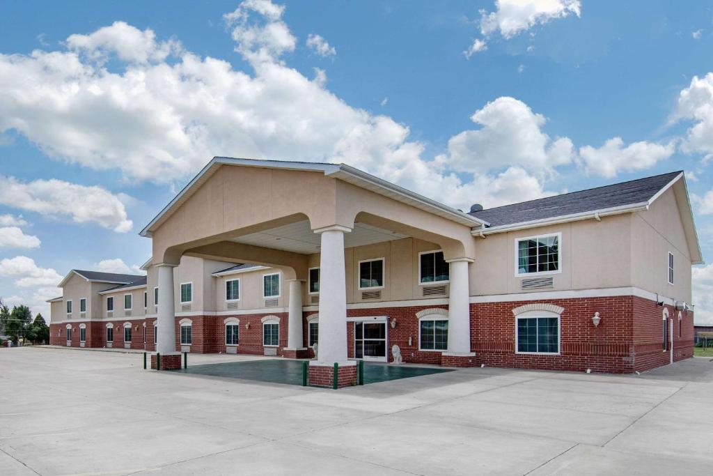 a large red brick building with white columns at Quality Inn & Suites in Clayton