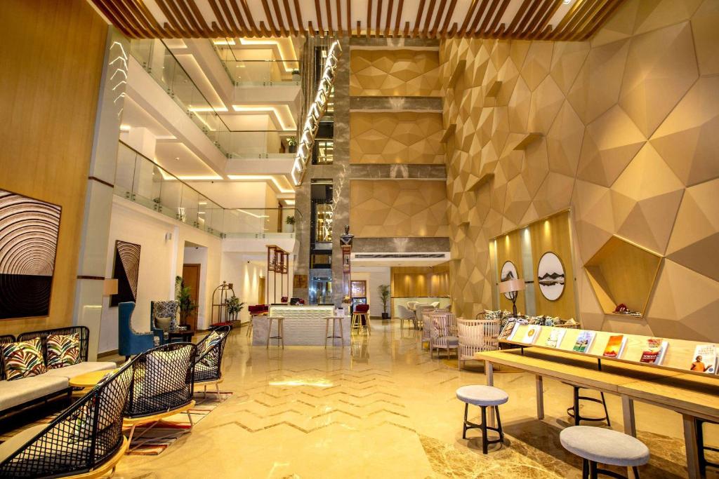 a lobby with chairs and tables in a store at Ramada by Wyndham Katra Station Road in Katra