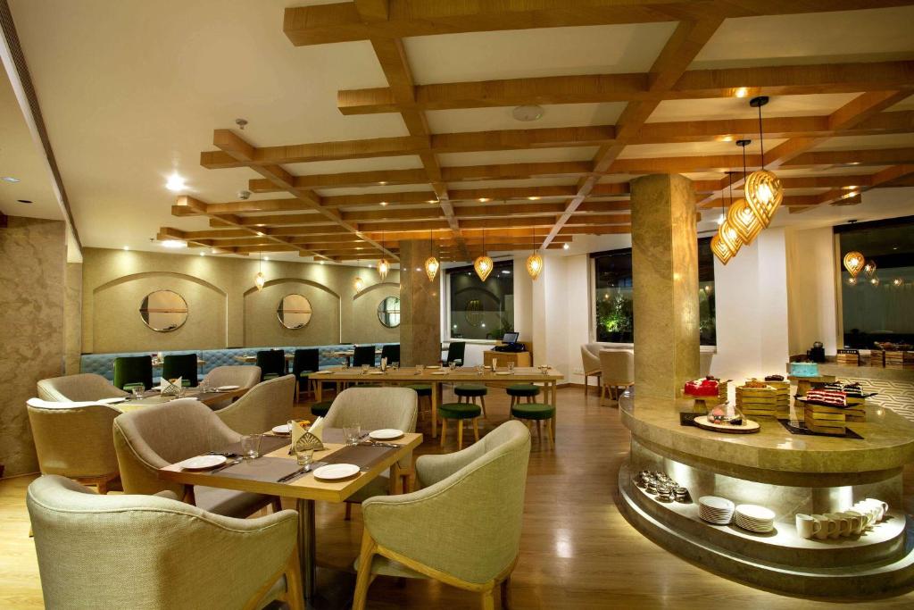 a dining room with tables and chairs and a restaurant at Ramada by Wyndham Katra Station Road in Katra