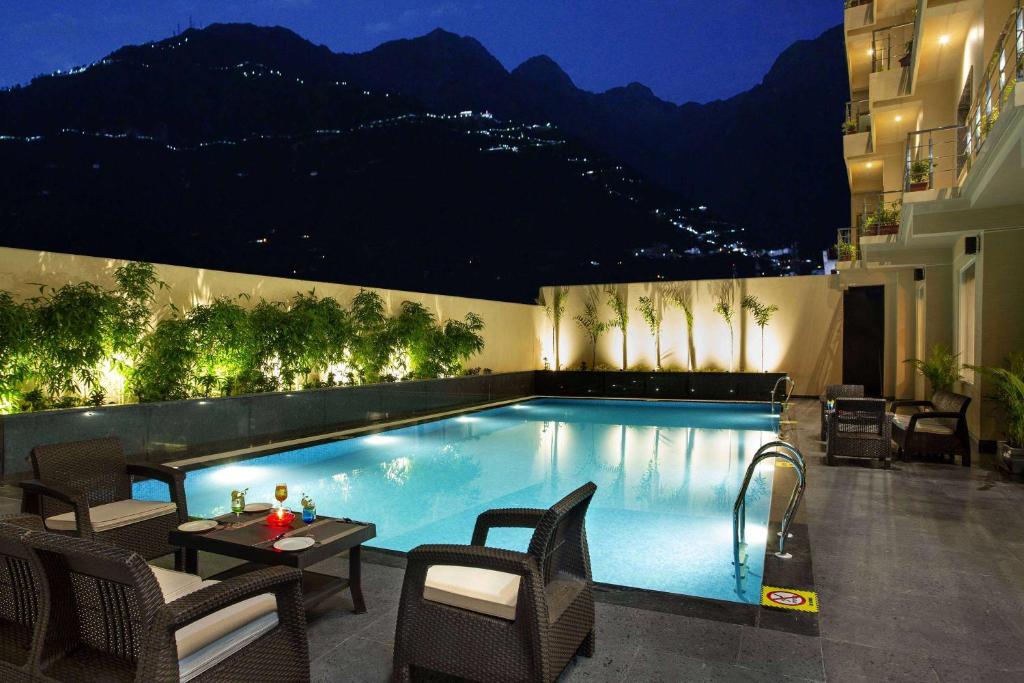 a swimming pool in a hotel at night at Ramada by Wyndham Katra Station Road in Katra