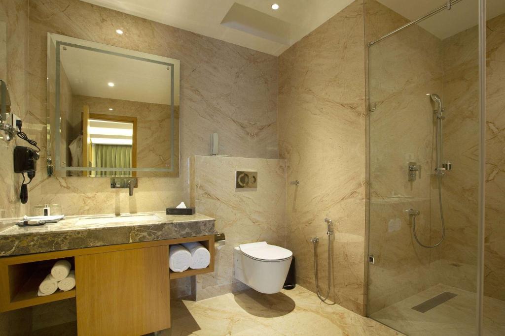 a bathroom with a shower and a sink and a toilet at Ramada by Wyndham Katra Station Road in Katra