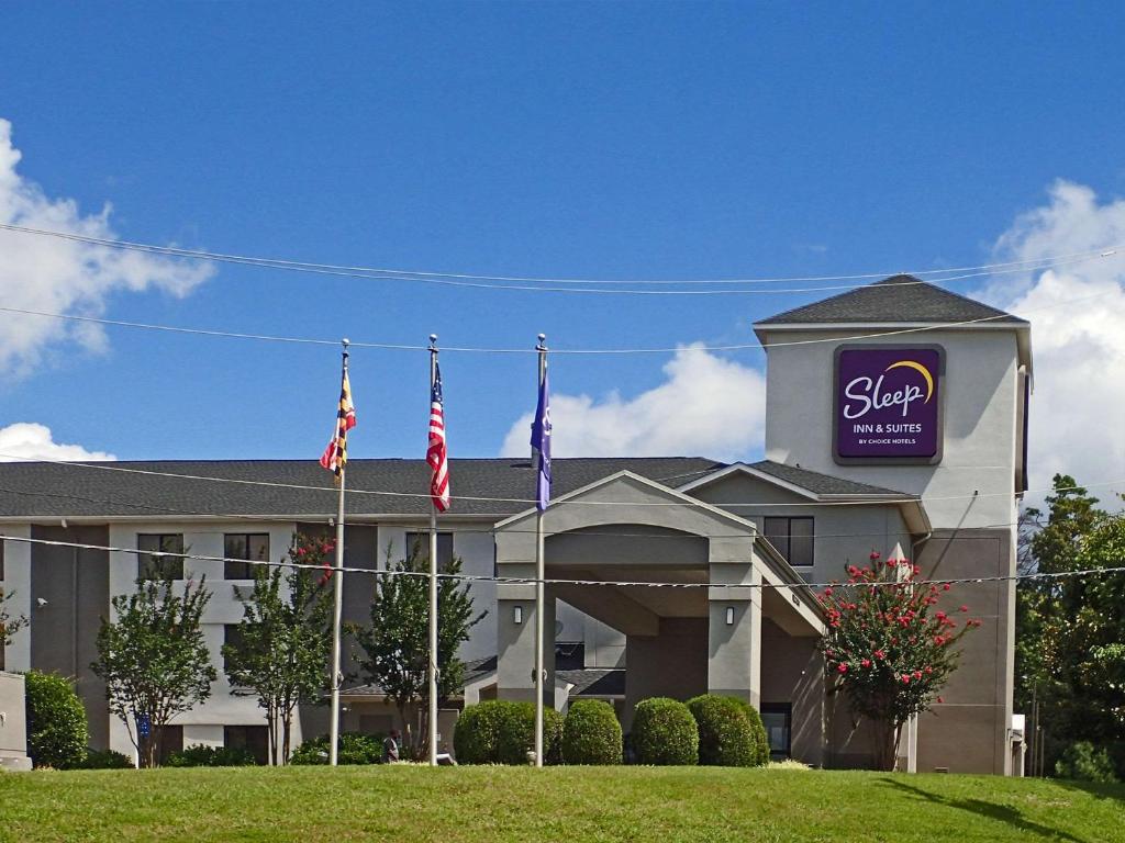 ein Hotel mit drei Flaggen davor in der Unterkunft Sleep Inn & Suites in California