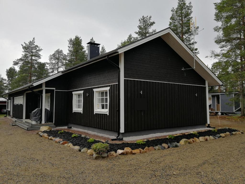 ein schwarzes Haus mit in der Unterkunft Maglelin Experience Lodge in Kittilä