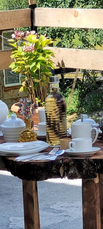 een tafel met borden en bekers en een vaas erop bij Guest House Guli in Mestia