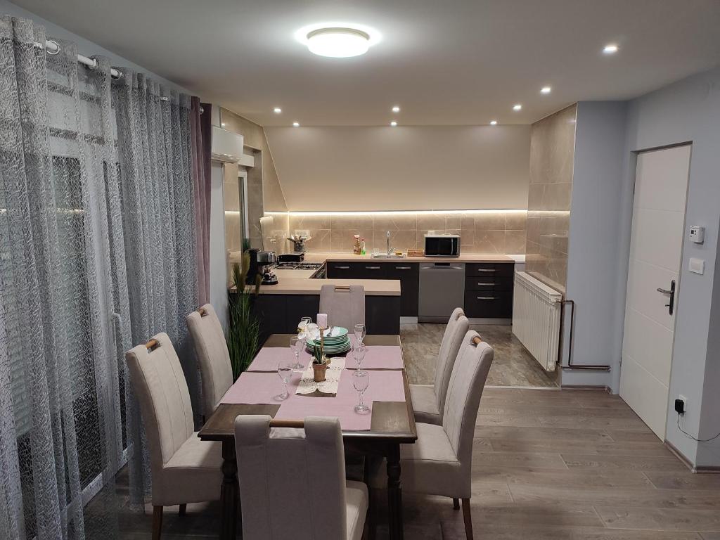 a dining room with a table and chairs and a kitchen at Apartman President in Krapinske Toplice